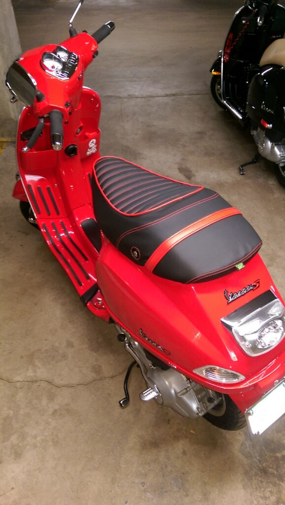 Rear view of black and red tuck-and-roll seat cover installed on a red Vespa S by Cheeky Seats