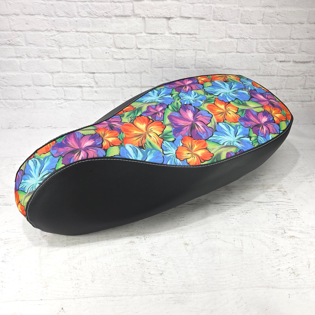 Side profile of the Hawaiian Flower scooter seat cover showing black panels, contrast stitching and a tailored fit, handmade by Cheeky Seats.