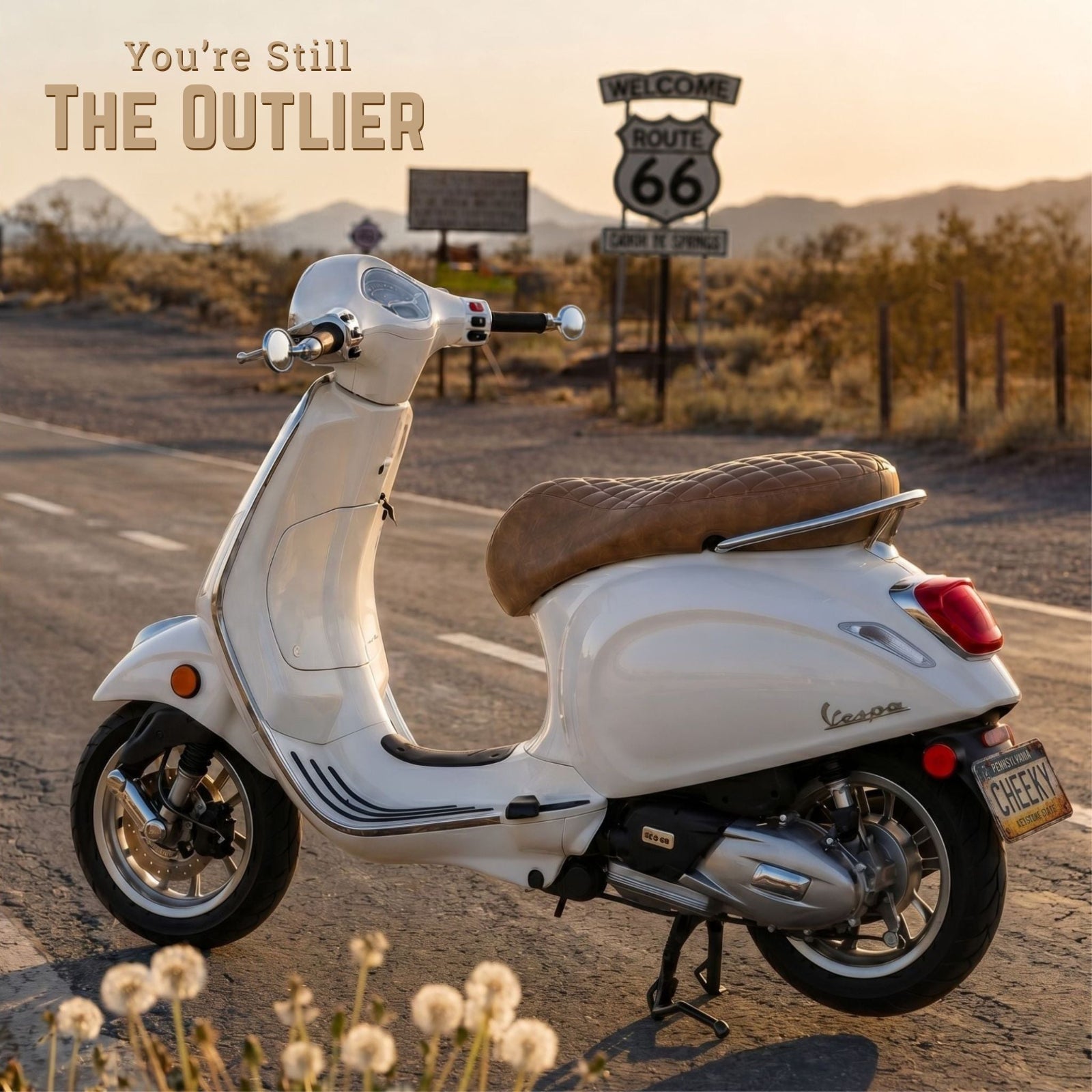 Cheeky Seats handmade scooter seat cover on a white Vespa on Route 66 with the message “You’re Still The Outlier”.